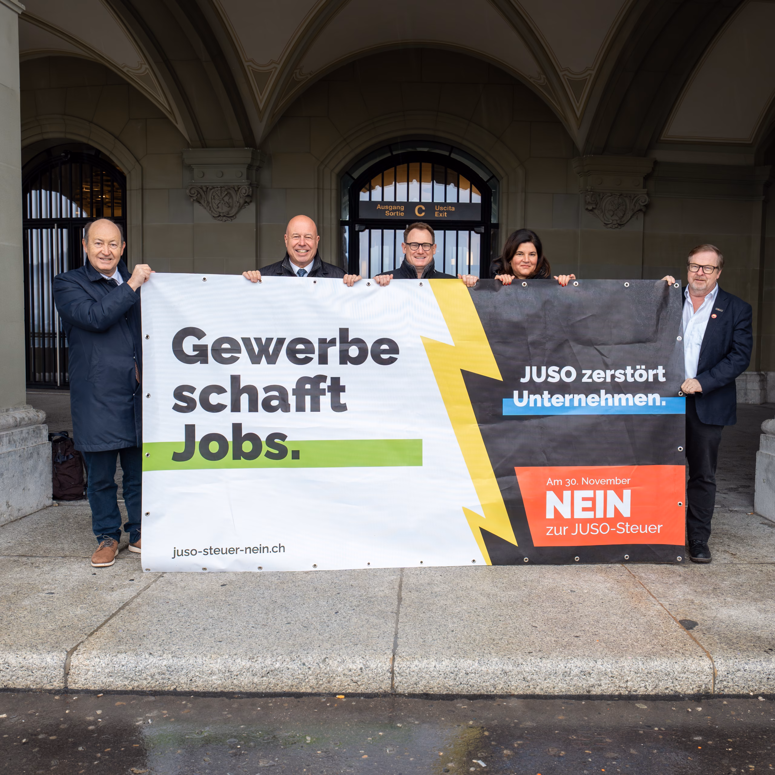 Banner «Gewerbe schafft Jobs» der Kampagne gegen die JUSO-Steuer mit Vertreterinnen und Vertretern des Komitees